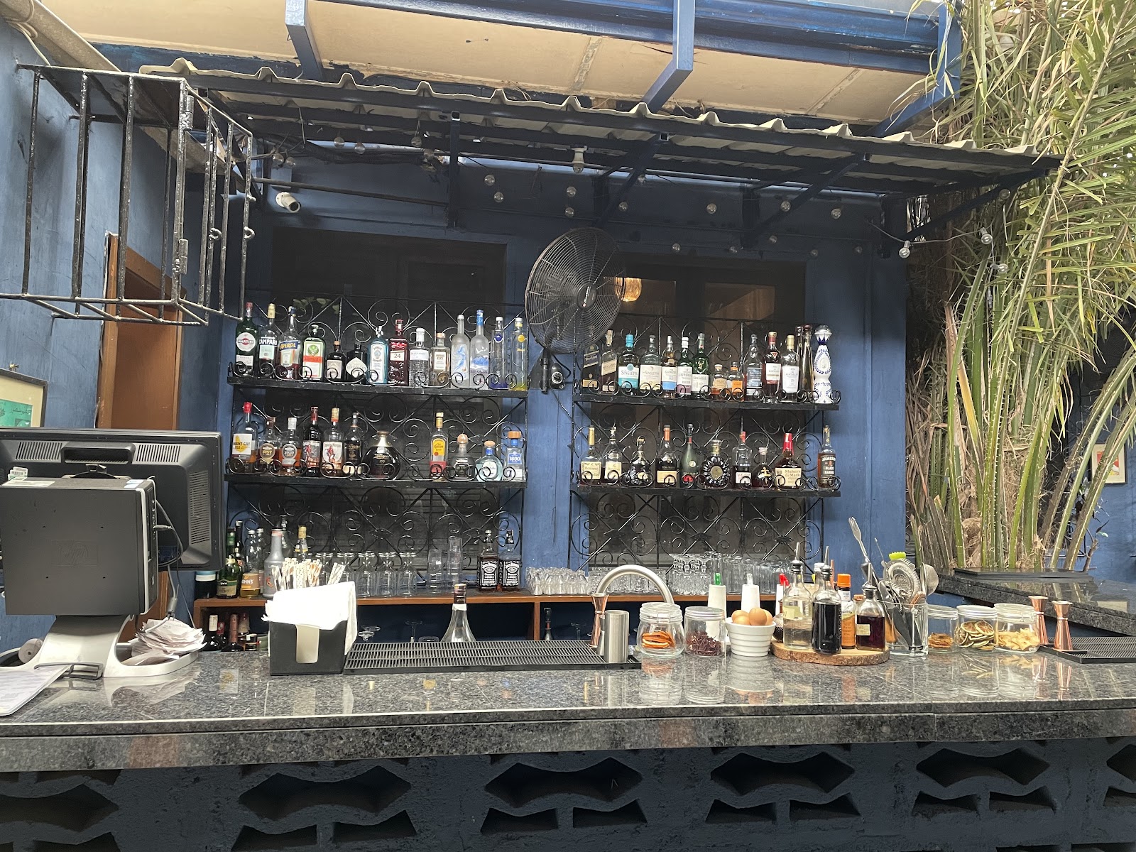 Intimate dark cocktail bar with warm low lighting, similar in mood to Front/Back Accra