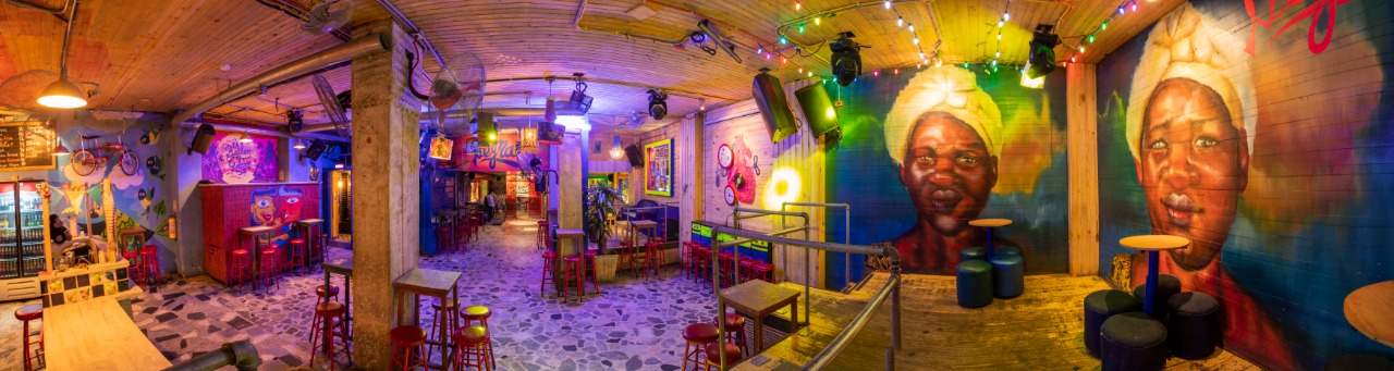Crowded night bar with colored lights, similar in mood to Bar La Negra in Bogotá