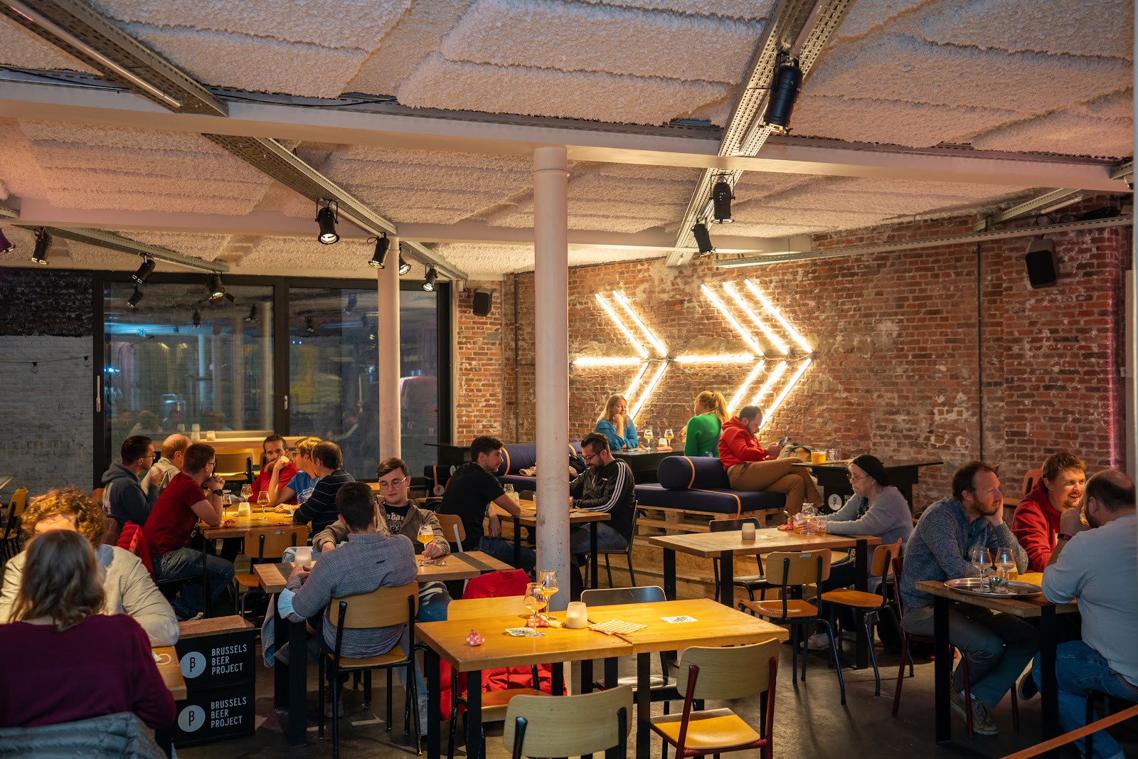 Craft beer taps and glassware in an industrial taproom, similar in feel to Brussels Beer Project