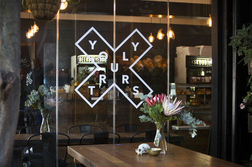 Relaxed pub interior with wooden tables and daylight, similar in feel to Yours Truly Cape Town
