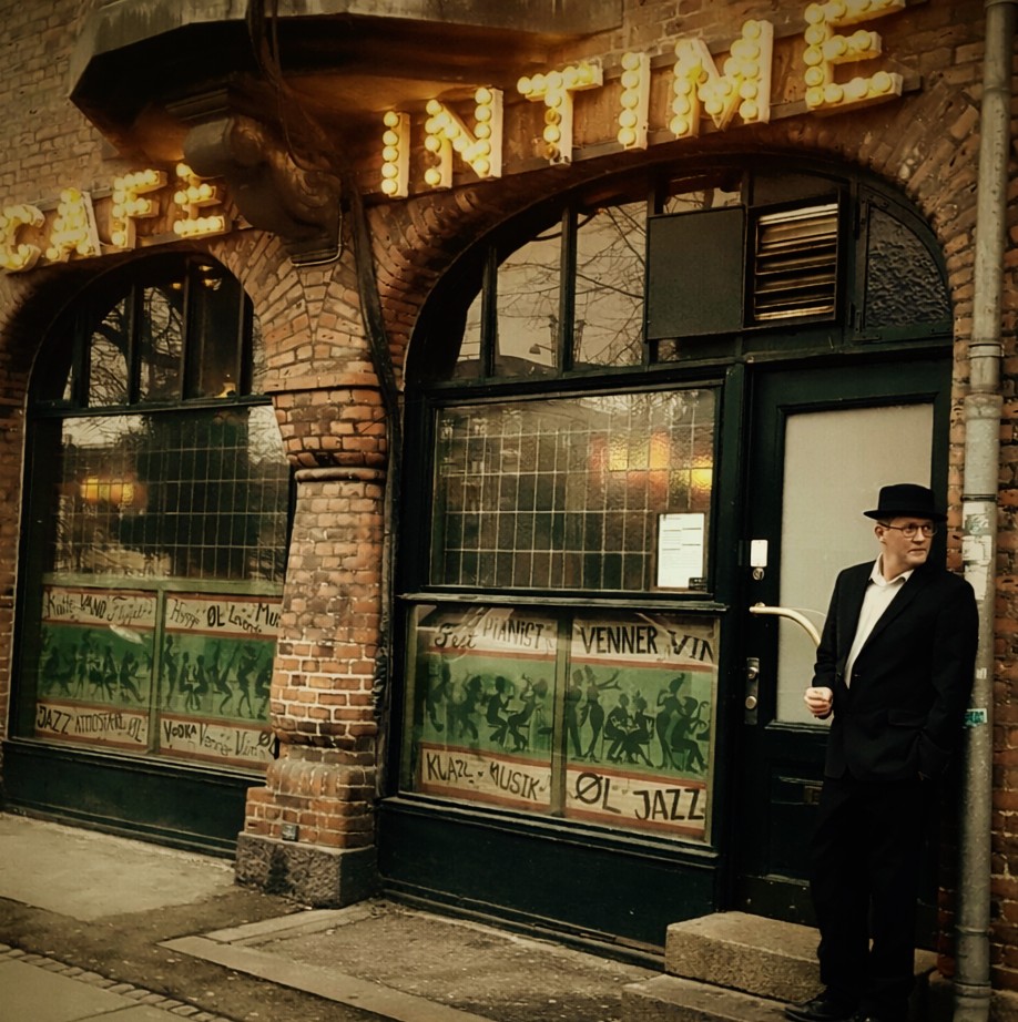 Intimate piano bar in warm low light, similar in mood to Café Intime in Copenhagen