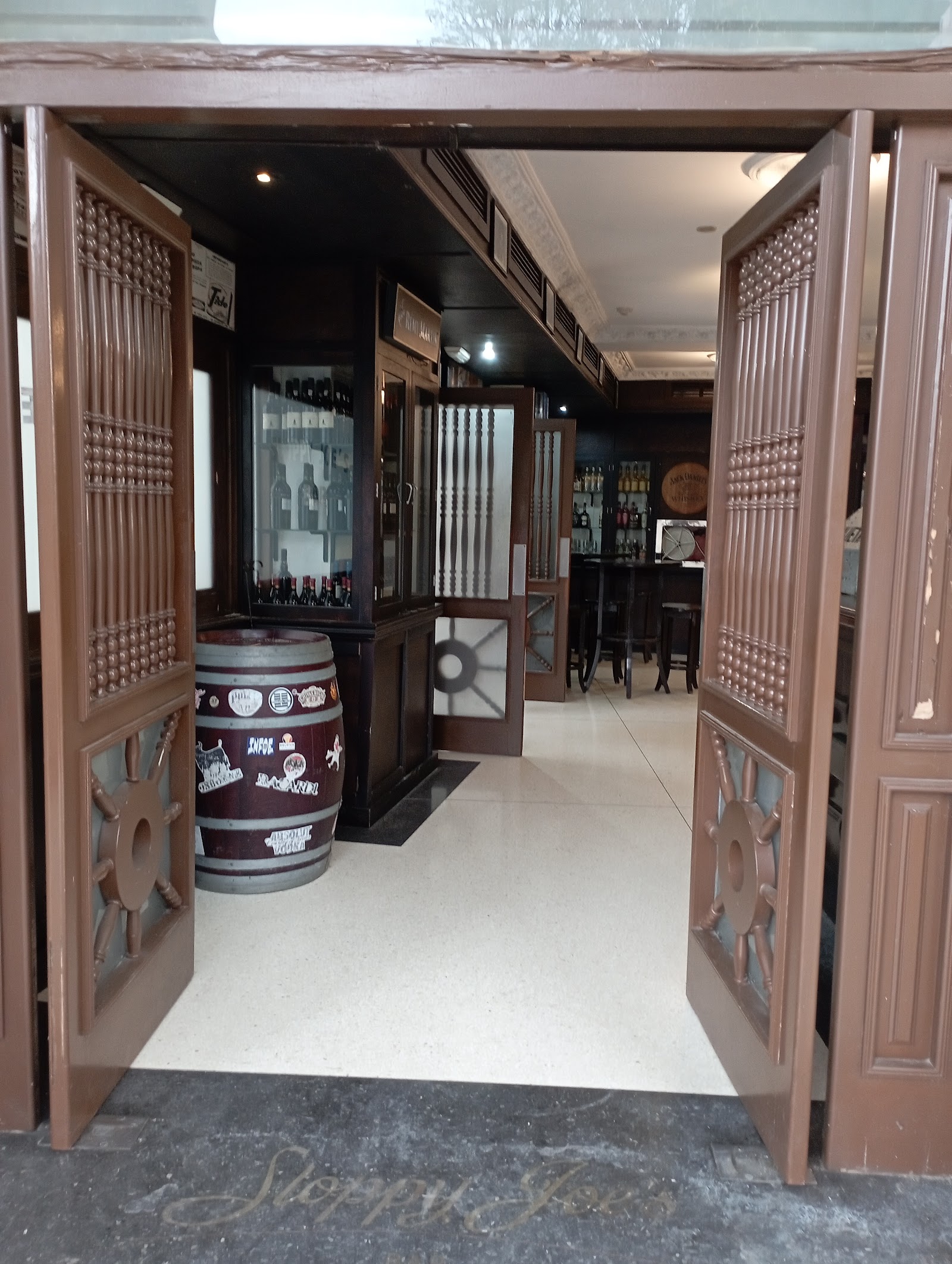 Long polished wooden bar in a historic room, similar in feel to Sloppy Joe's Bar Havana