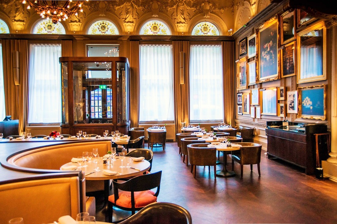 Grand banking-hall bar with high corniced ceiling at The London EDITION Fitzrovia