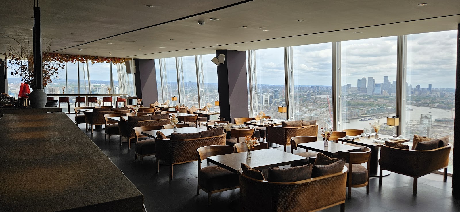 Dark polished bar interior with city lights beyond the glass