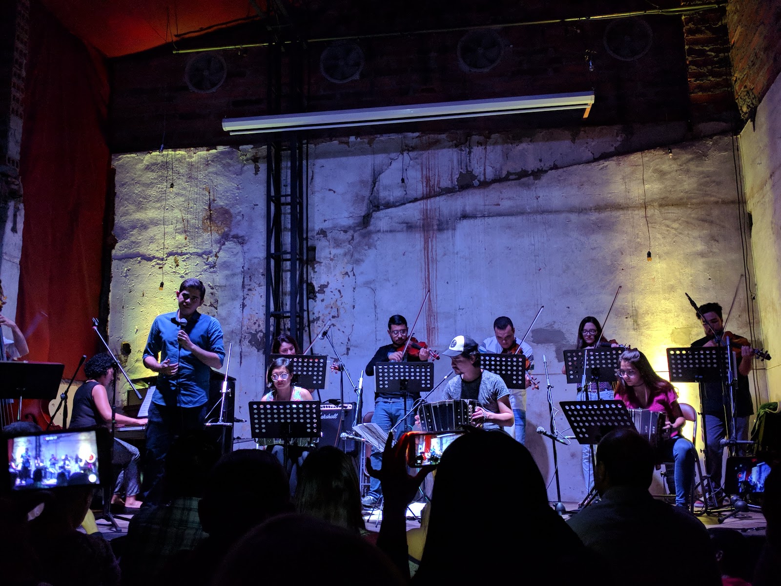 Musicians playing in a dim room, similar in mood to La Pascasia in Medellín