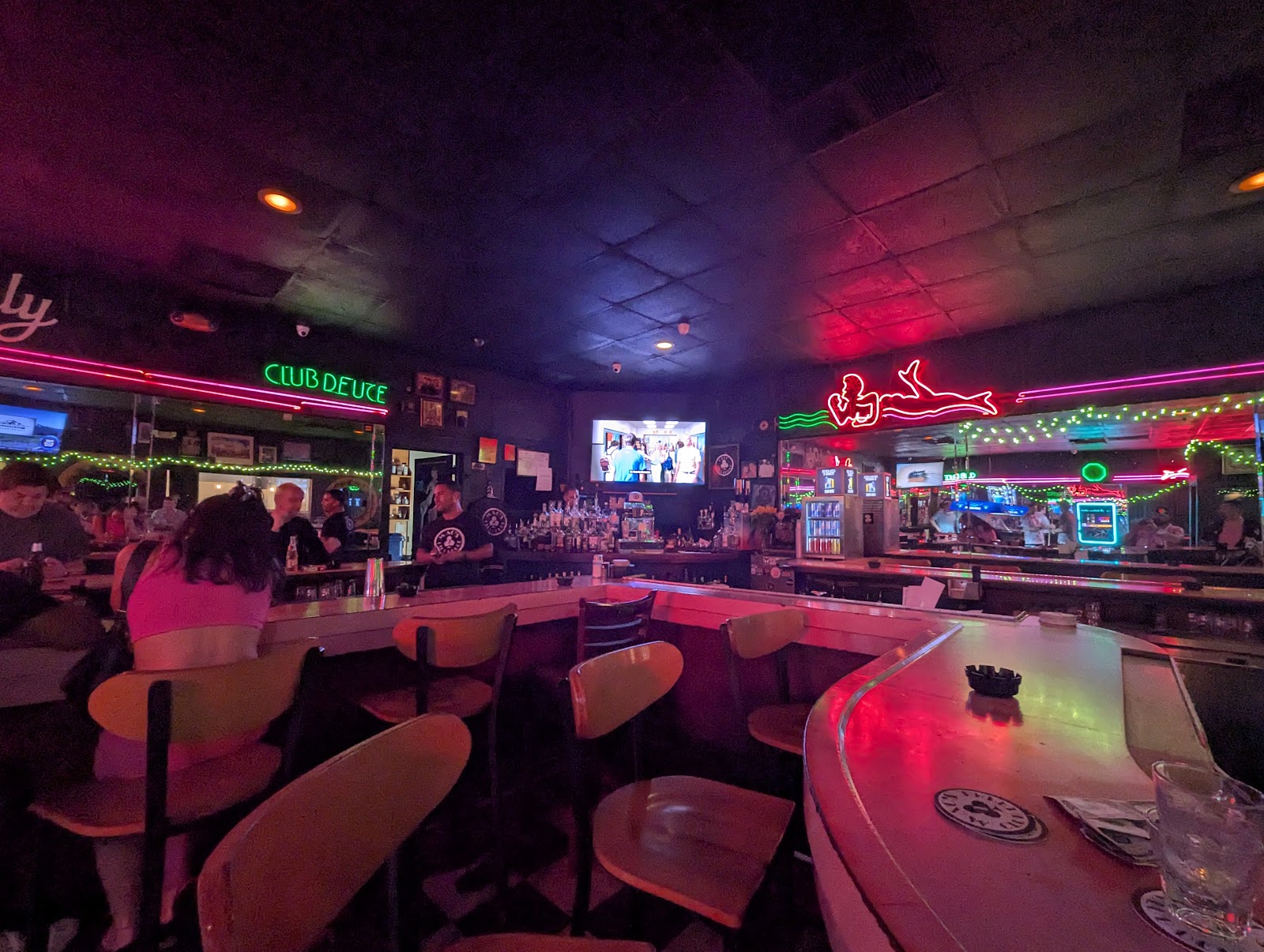 Worn bar stools along a dive bar rail