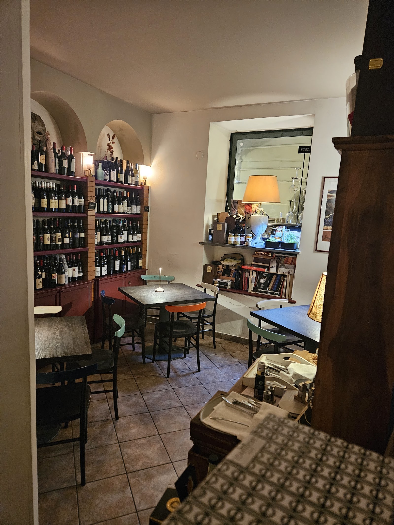 Wine bottles lining the shelves of a dark Naples enoteca