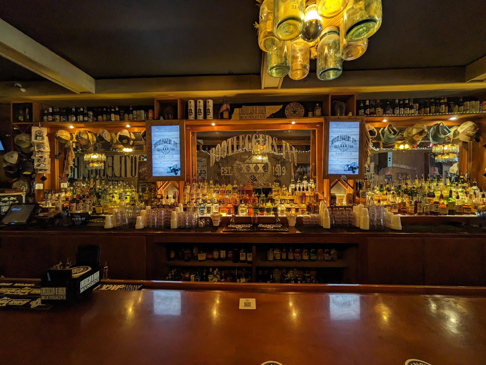 Backlit shelf of moonshine and whiskey bottles in a Nashville honky tonk