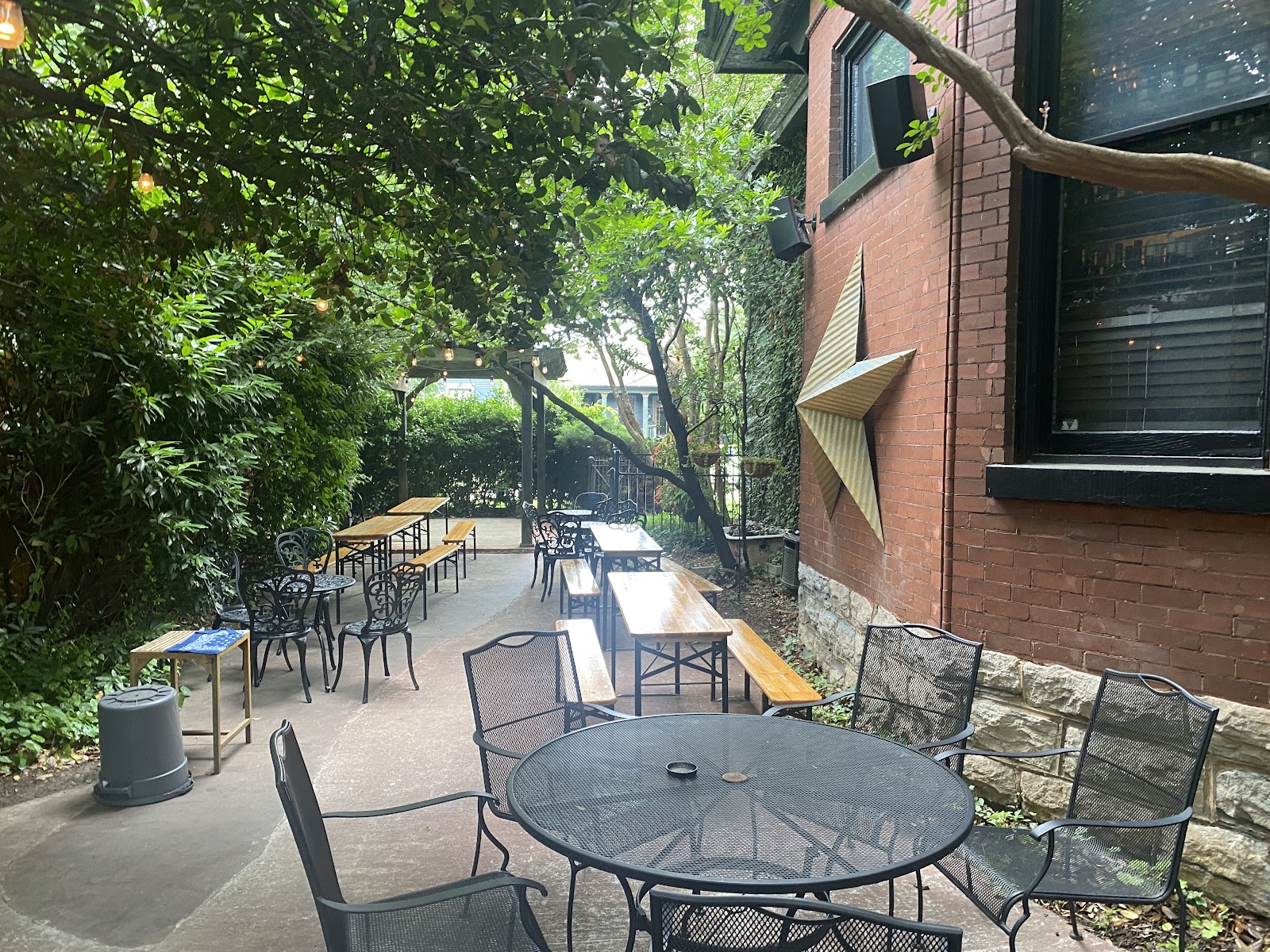 Garden cocktail courtyard strung with lights behind a bar in East Nashville