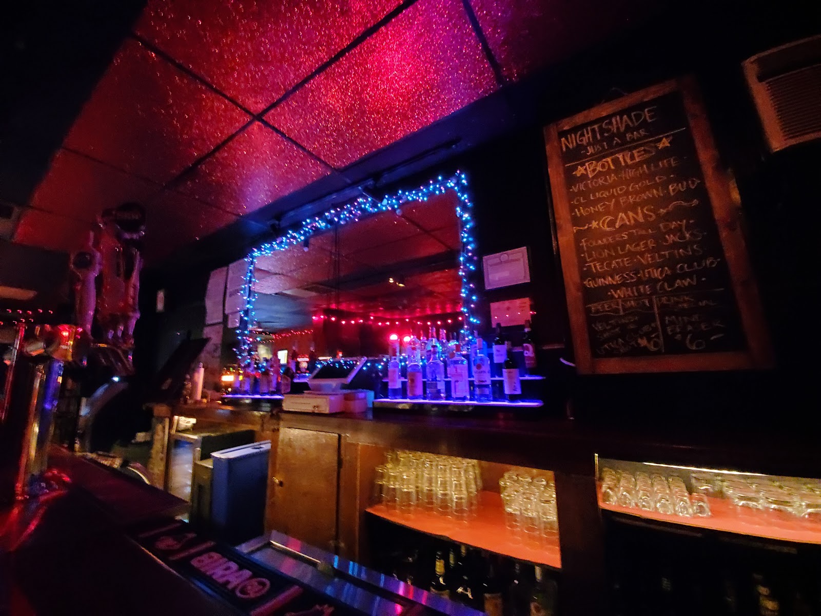 Dim, jukebox-lit dive bar interior at night, Greenpoint Brooklyn