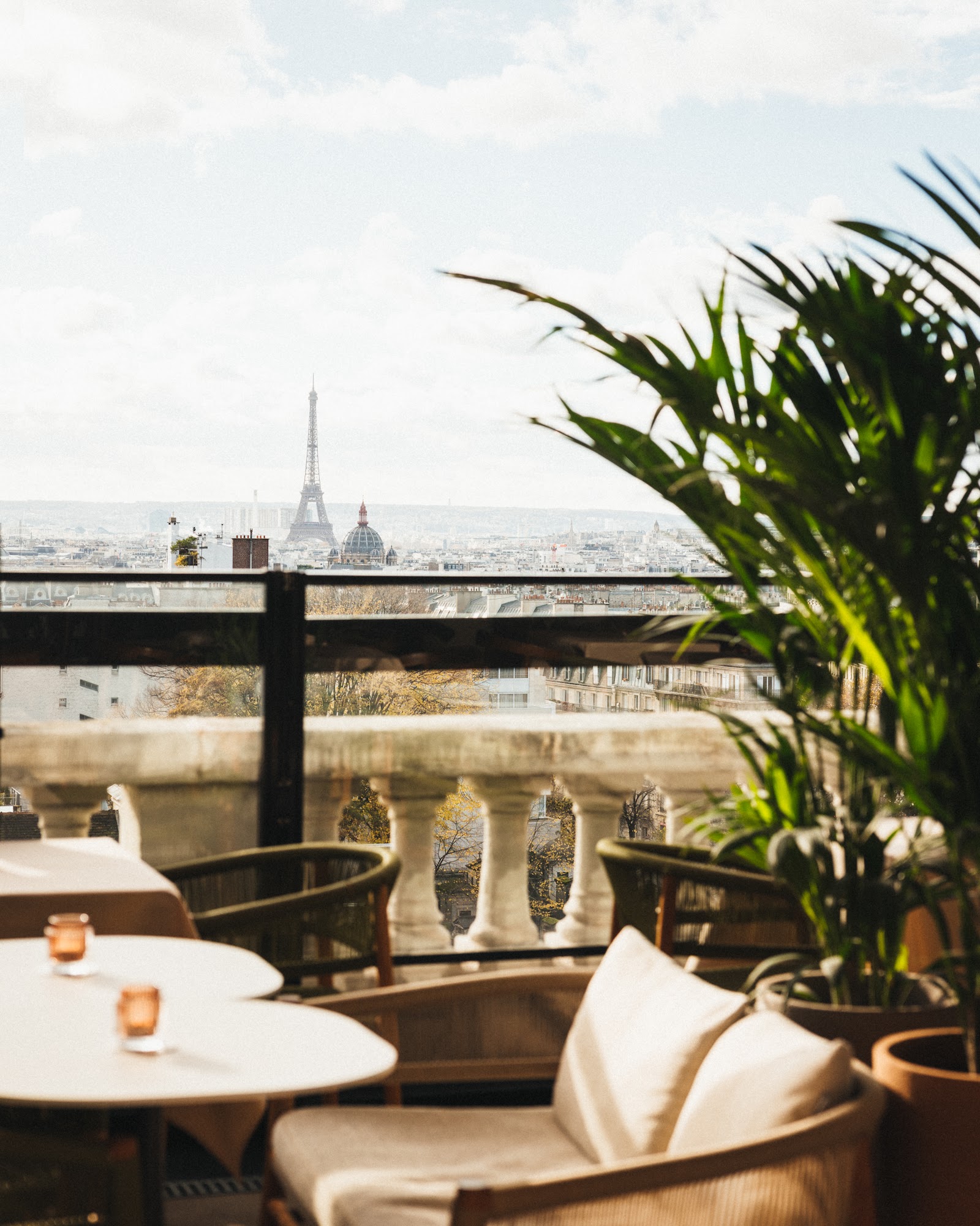 Paris rooftop bar at dusk with the city skyline and Eiffel Tower beyond