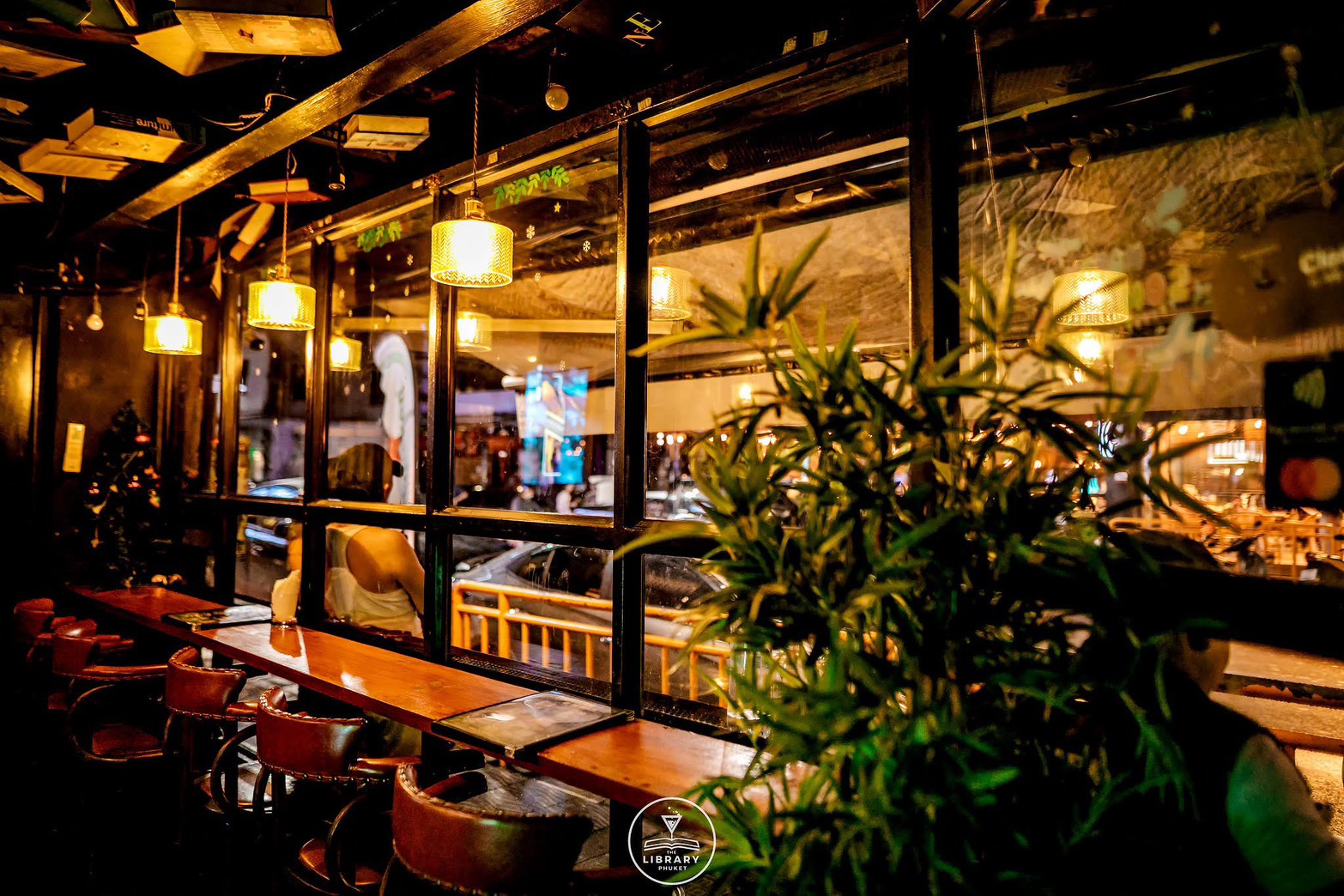 Dark cocktail bar with shelved back bar like library stacks
