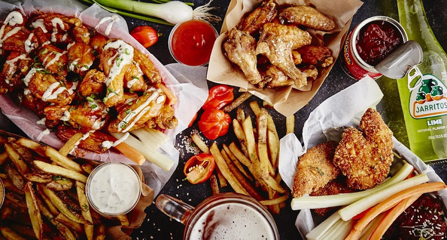 Plates of American wings and a glass of Czech draft beer