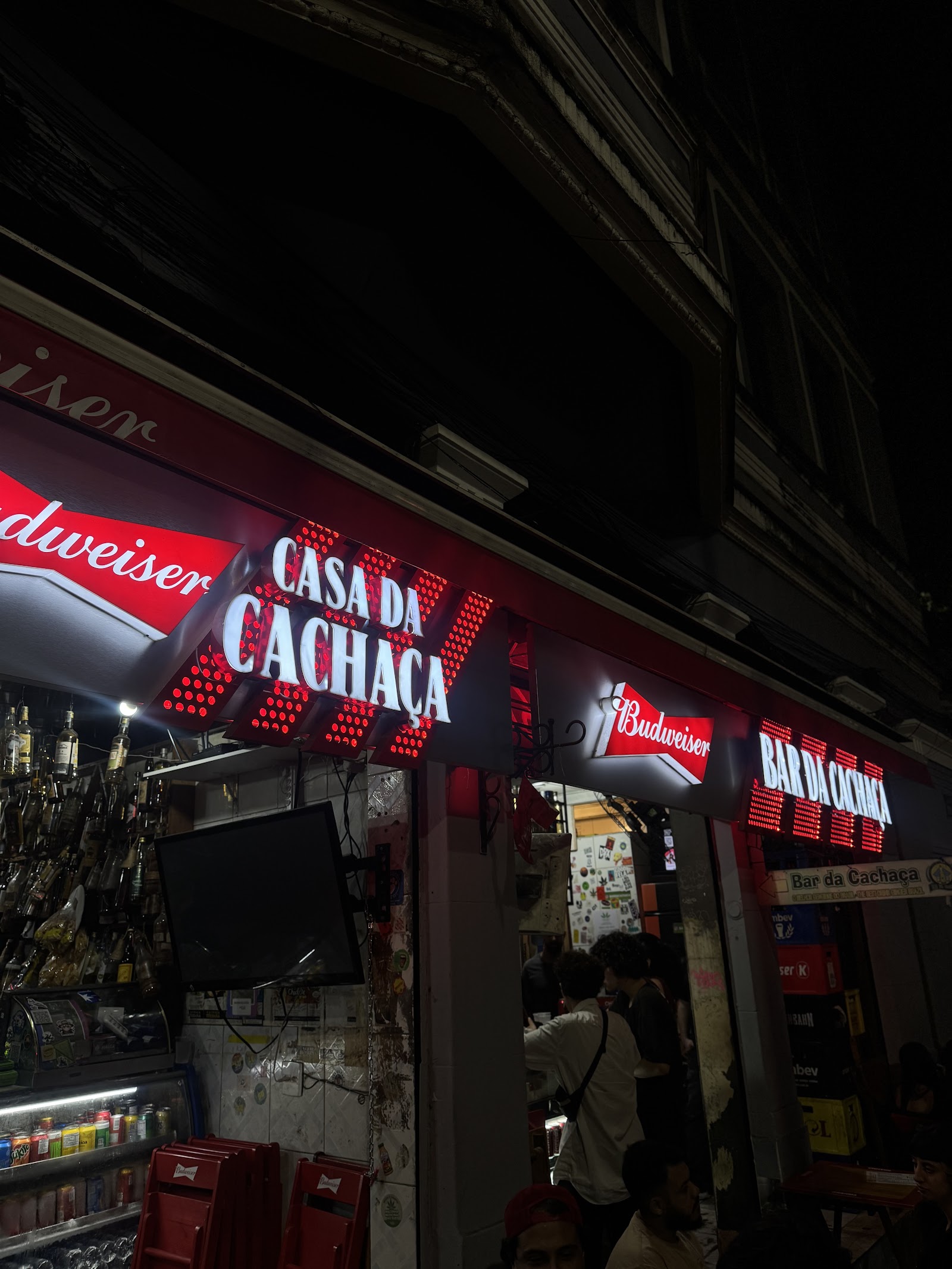 Bottles of artisanal cachaca lined up behind a small Lapa bar