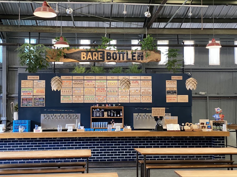 Open warehouse taproom with long tables at Barebottle Brewing