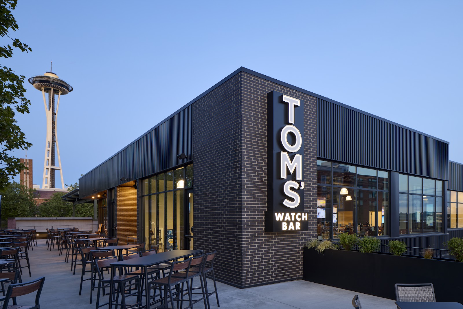 Tom's Watch Bar interior with wall-to-wall screens near Climate Pledge Arena