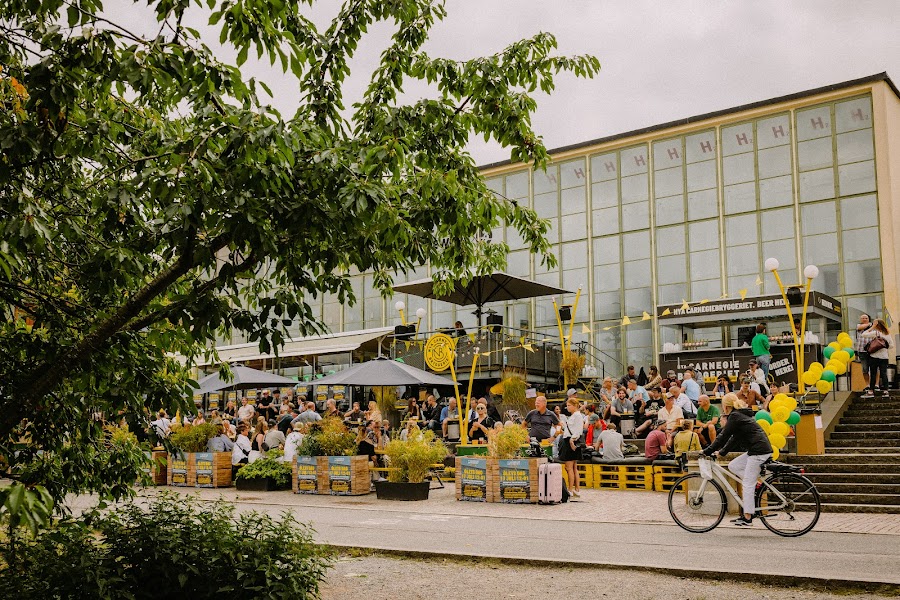 Brewery tanks behind a long taproom bar by the water