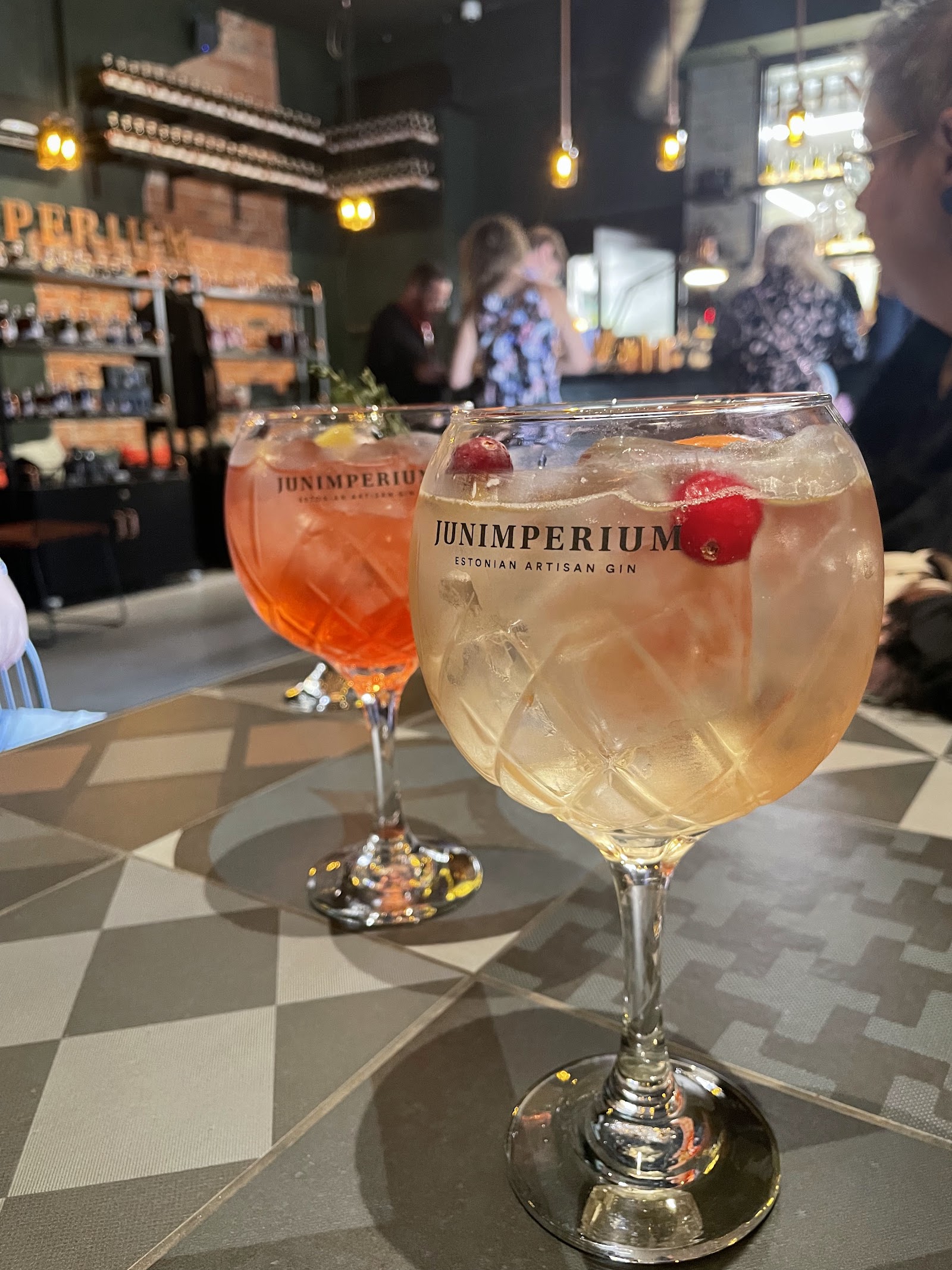 Copper stills and a bar counter inside a distillery room