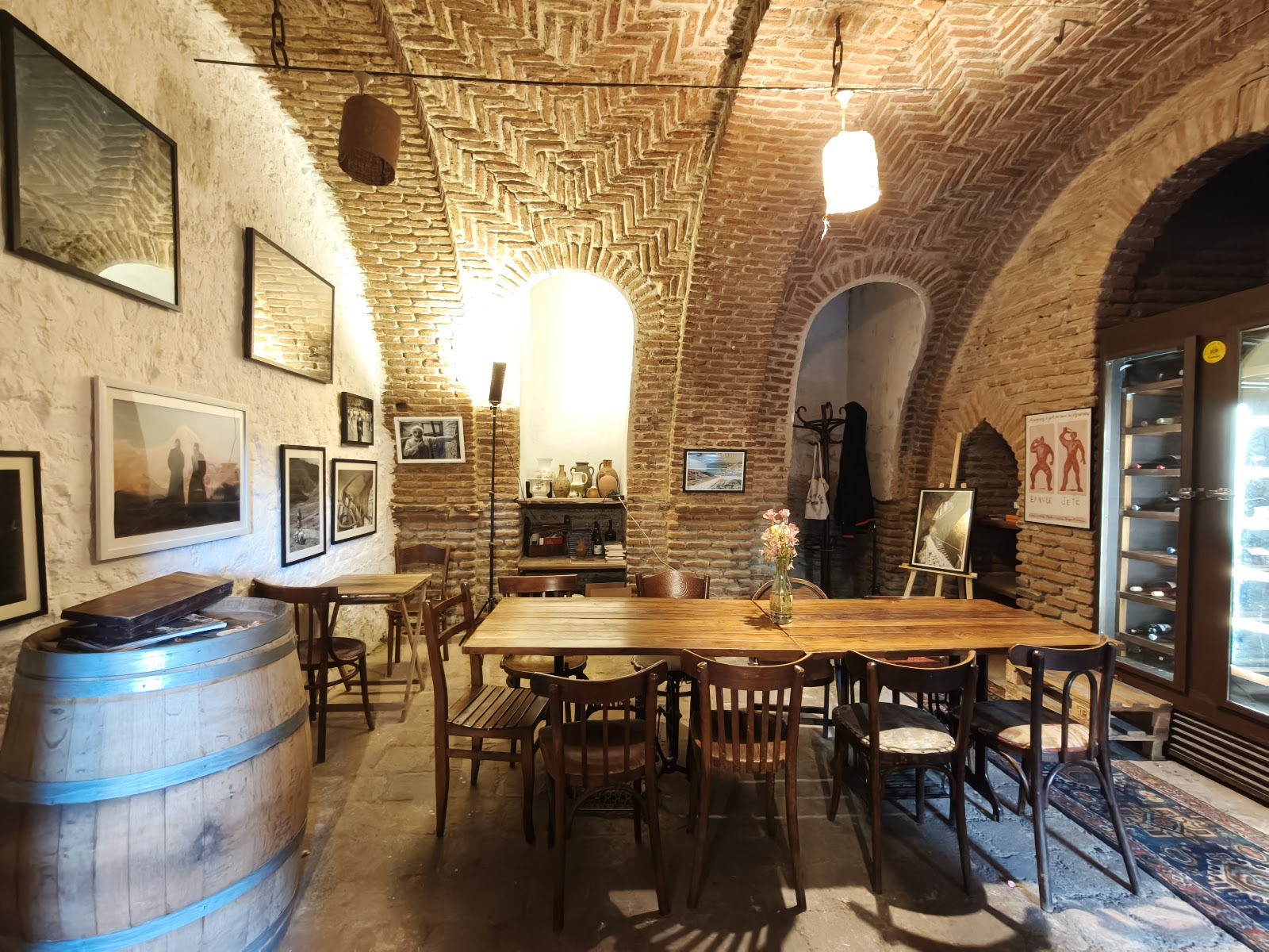 Brick vaulted wine cellar lit low with bottles along the wall