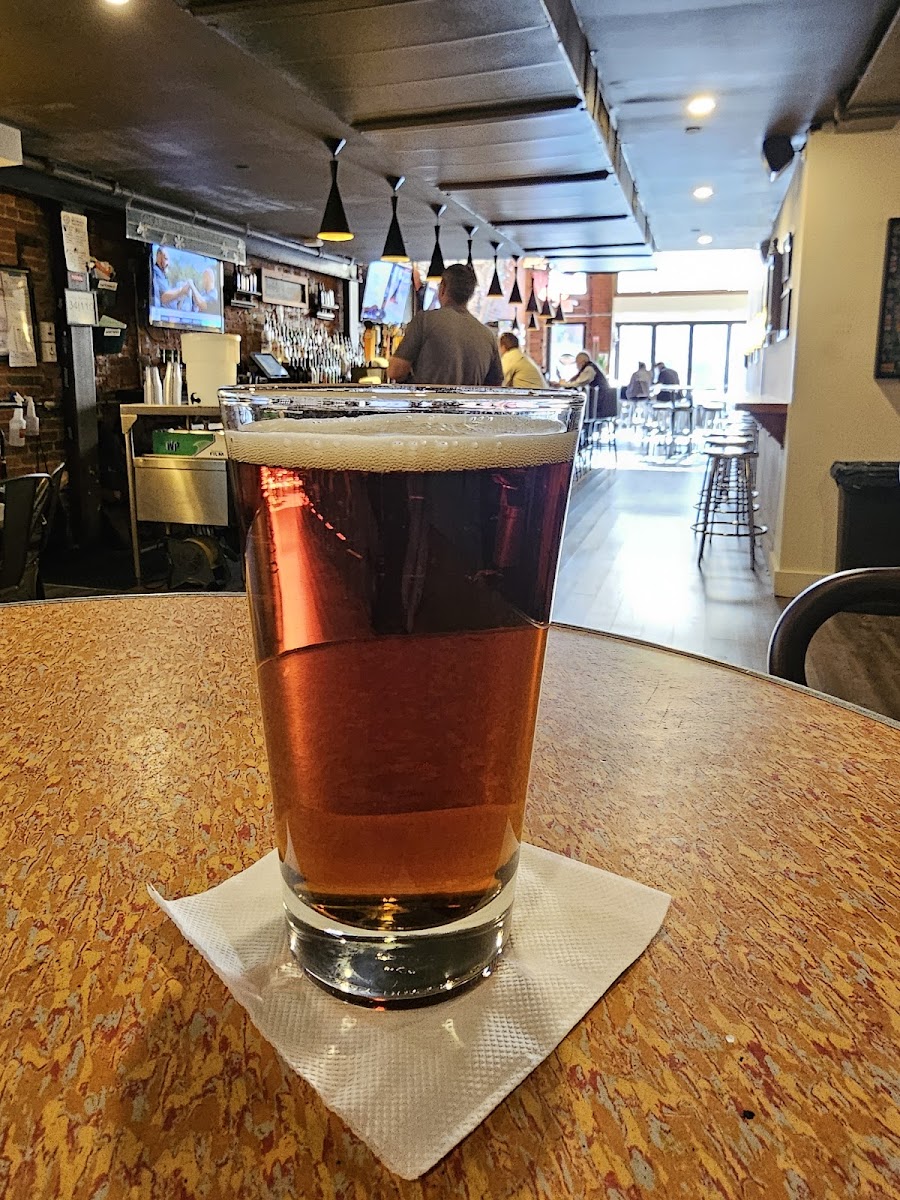 A craft beer beside a stack of board games
