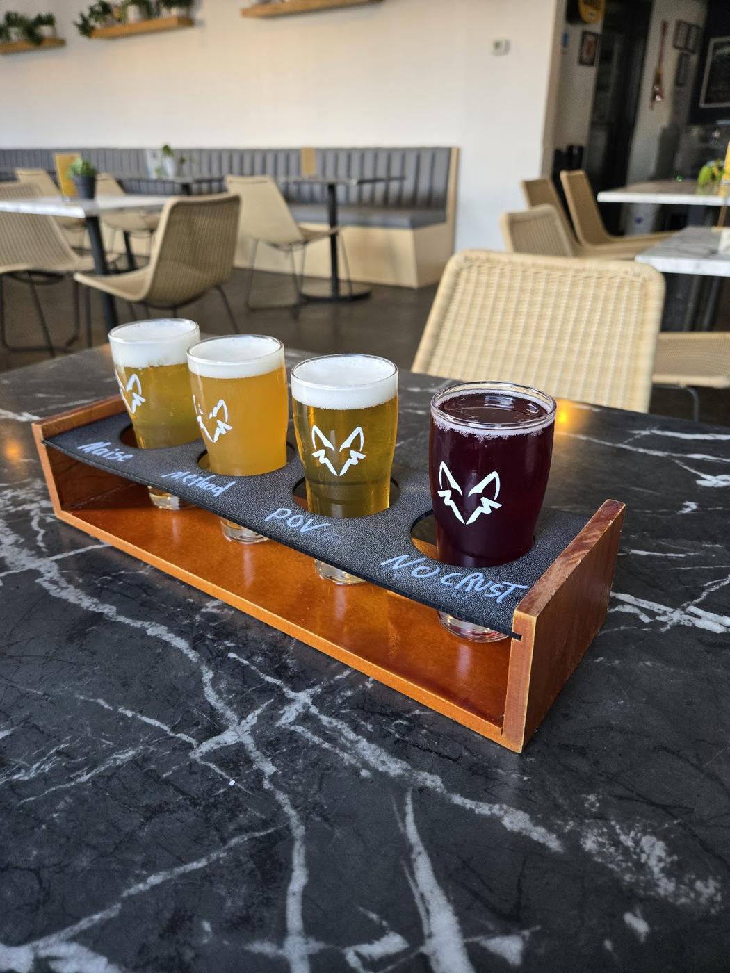 Flight of craft beers on a wooden taproom table