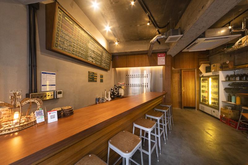 Glasses of beer lined up on a wooden bar counter